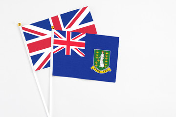 Fototapeta premium British Virgin Islands and United Kingdom stick flags on white background. High quality fabric, miniature national flag. Peaceful global concept.White floor for copy space.