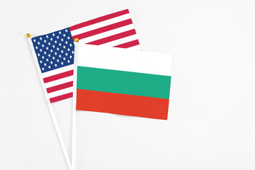 Bulgaria and United States stick flags on white background. High quality fabric, miniature national flag. Peaceful global concept.White floor for copy space.