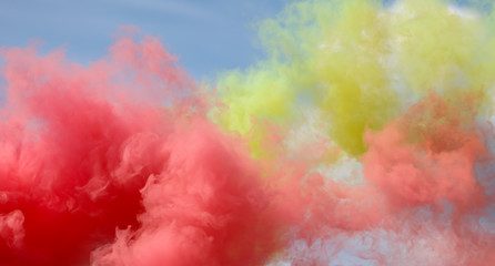 Red and yellow smoke on a blue sky