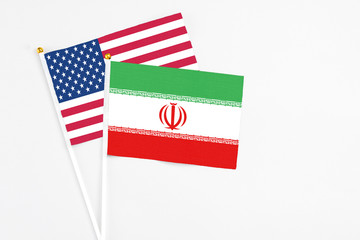 Iran and United States stick flags on white background. High quality fabric, miniature national flag. Peaceful global concept.White floor for copy space.