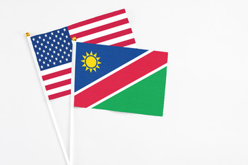 Namibia and United States stick flags on white background. High quality fabric, miniature national flag. Peaceful global concept.White floor for copy space.