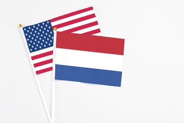 Netherlands and United States stick flags on white background. High quality fabric, miniature national flag. Peaceful global concept.White floor for copy space.