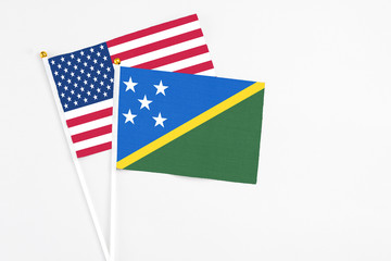 Solomon Islands and United States stick flags on white background. High quality fabric, miniature national flag. Peaceful global concept.White floor for copy space.