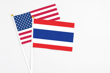 Thailand and United States stick flags on white background. High quality fabric, miniature national flag. Peaceful global concept.White floor for copy space.