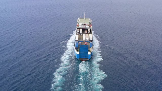 Aerial follow footage of a Large RoRo (Roll on/off) Vehicle carrier vessel cruising the Mediterranean sea.