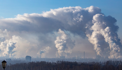 Fototapeta na wymiar Smoke from the chimneys of a metallurgical plant at dawn