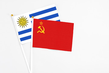 Soviet Union and Uruguay stick flags on white background. High quality fabric, miniature national flag. Peaceful global concept.White floor for copy space.