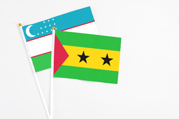 Sao Tome And Principe and Uzbekistan stick flags on white background. High quality fabric, miniature national flag. Peaceful global concept.White floor for copy space.