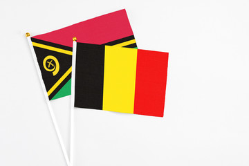 Belgium and Vanuatu stick flags on white background. High quality fabric, miniature national flag. Peaceful global concept.White floor for copy space.
