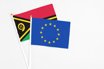 European Union and Vanuatu stick flags on white background. High quality fabric, miniature national flag. Peaceful global concept.White floor for copy space.