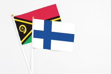 Finland and Vanuatu stick flags on white background. High quality fabric, miniature national flag. Peaceful global concept.White floor for copy space.