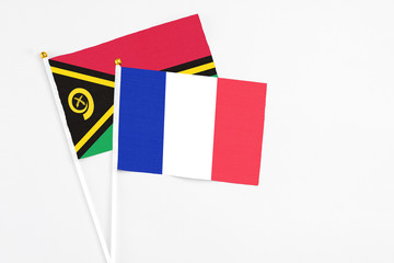 France and Vanuatu stick flags on white background. High quality fabric, miniature national flag. Peaceful global concept.White floor for copy space.