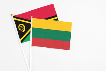 Lithuania and Vanuatu stick flags on white background. High quality fabric, miniature national flag. Peaceful global concept.White floor for copy space.