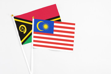 Malaysia and Vanuatu stick flags on white background. High quality fabric, miniature national flag. Peaceful global concept.White floor for copy space.