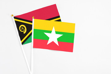 Myanmar and Vanuatu stick flags on white background. High quality fabric, miniature national flag. Peaceful global concept.White floor for copy space.