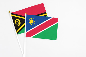 Namibia and Vanuatu stick flags on white background. High quality fabric, miniature national flag. Peaceful global concept.White floor for copy space.
