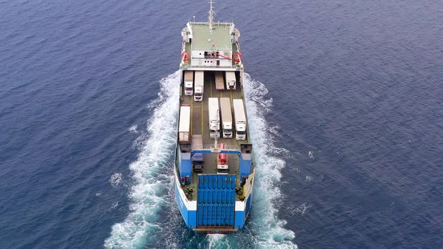 Aerial follow footage of a Large RoRo (Roll on/off) Vehicle carrier vessel cruising the Mediterranean sea.
