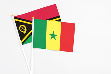 Senegal and Vanuatu stick flags on white background. High quality fabric, miniature national flag. Peaceful global concept.White floor for copy space.