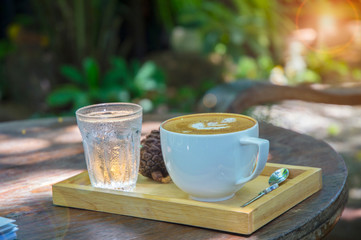 Cup with tea on table over mountains landscape with sunlight. Beauty nature background