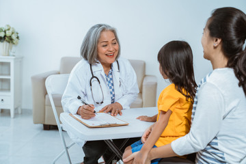 Fototapeta premium Female doctor records complaints of pain from children who use the clipboard