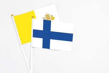 Finland and Vatican City stick flags on white background. High quality fabric, miniature national...