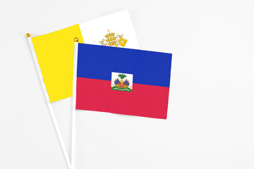 Haiti and Vatican City stick flags on white background. High quality fabric, miniature national...