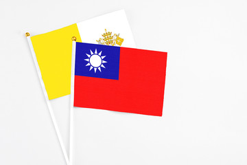 Taiwan and Vatican City stick flags on white background. High quality fabric, miniature national flag. Peaceful global concept.White floor for copy space.