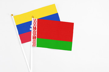Belarus and Venezuela stick flags on white background. High quality fabric, miniature national flag. Peaceful global concept.White floor for copy space.