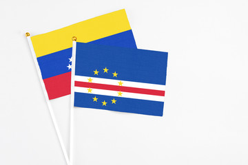 Cape Verde and Venezuela stick flags on white background. High quality fabric, miniature national flag. Peaceful global concept.White floor for copy space.