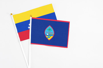 Guam and Venezuela stick flags on white background. High quality fabric, miniature national flag. Peaceful global concept.White floor for copy space.