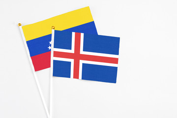 Obraz premium Iceland and Venezuela stick flags on white background. High quality fabric, miniature national flag. Peaceful global concept.White floor for copy space.