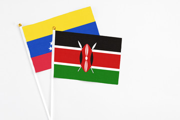 Kenya and Venezuela stick flags on white background. High quality fabric, miniature national flag. Peaceful global concept.White floor for copy space.