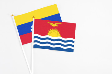 Kiribati and Venezuela stick flags on white background. High quality fabric, miniature national flag. Peaceful global concept.White floor for copy space.