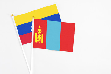 Mongolia and Venezuela stick flags on white background. High quality fabric, miniature national flag. Peaceful global concept.White floor for copy space.