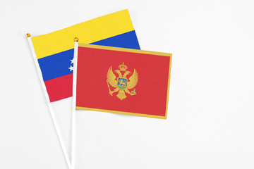 Montenegro and Venezuela stick flags on white background. High quality fabric, miniature national flag. Peaceful global concept.White floor for copy space.