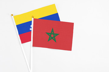 Morocco and Venezuela stick flags on white background. High quality fabric, miniature national flag. Peaceful global concept.White floor for copy space.