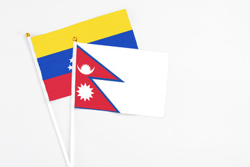 Nepal and Venezuela stick flags on white background. High quality fabric, miniature national flag. Peaceful global concept.White floor for copy space.