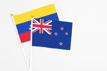 Fototapeta premium New Zealand and Venezuela stick flags on white background. High quality fabric, miniature national flag. Peaceful global concept.White floor for copy space.