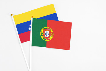 Portugal and Venezuela stick flags on white background. High quality fabric, miniature national flag. Peaceful global concept.White floor for copy space.