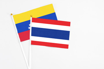 Thailand and Venezuela stick flags on white background. High quality fabric, miniature national flag. Peaceful global concept.White floor for copy space.