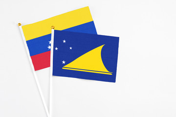 Tokelau and Venezuela stick flags on white background. High quality fabric, miniature national flag. Peaceful global concept.White floor for copy space.
