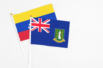 Fototapeta premium British Virgin Islands and Venezuela stick flags on white background. High quality fabric, miniature national flag. Peaceful global concept.White floor for copy space.