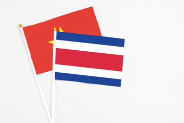 Costa Rica and Vietnam stick flags on white background. High quality fabric, miniature national flag. Peaceful global concept.White floor for copy space.