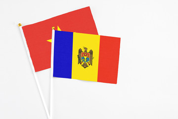 Moldova and Vietnam stick flags on white background. High quality fabric, miniature national flag. Peaceful global concept.White floor for copy space.
