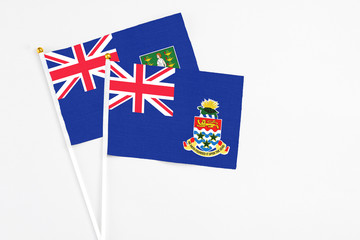 Fototapeta premium Cayman Islands and British Virgin Islands stick flags on white background. High quality fabric, miniature national flag. Peaceful global concept.White floor for copy space.