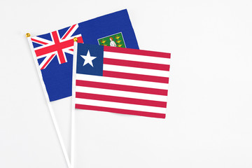Liberia and British Virgin Islands stick flags on white background. High quality fabric, miniature national flag. Peaceful global concept.White floor for copy space.