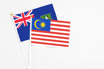 Malaysia and British Virgin Islands stick flags on white background. High quality fabric, miniature national flag. Peaceful global concept.White floor for copy space.