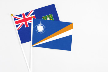Fototapeta premium Marshall Islands and British Virgin Islands stick flags on white background. High quality fabric, miniature national flag. Peaceful global concept.White floor for copy space.