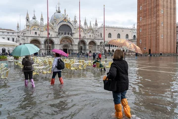 Fototapeten VENICE, ITALY - November 12, 2019: St. Marks Square (Piazza San Marco) during flood (acqua alta) in Venice, Italy. Venice high water. Tourists at St. Mark's Square during high water © Ihor
