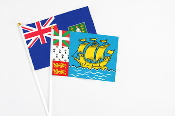 Saint Pierre And Miquelon and British Virgin Islands stick flags on white background. High quality fabric, miniature national flag. Peaceful global concept.White floor for copy space.